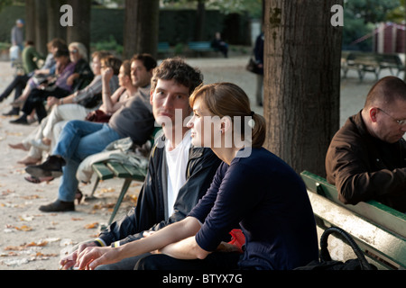 junges Paar Liebhaber auf einer Bank im Park der Kathedrale Notre-Dame in schönen Nachmittag leichte auf schönen Herbsttag in Paris Stockfoto