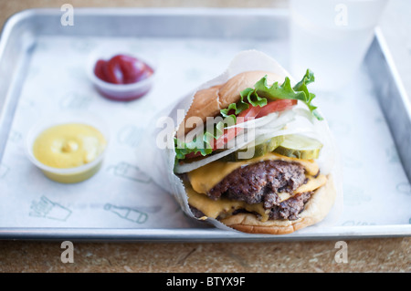 Eine doppelte Shackburger mit Saucen an Shake Shack, ein fast-casual-Restaurant in der Upper West Side in Manhattan, New York. Stockfoto