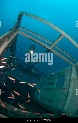 Taucher schwimmen über ein Schiffswrack. Unter Seaventures Dive Resort, Sabah, Borneo, Malaysia. Stockfoto