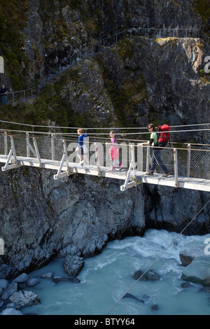 Familie der Wanderer überqueren Hooker Fluss Fußgängerbrücke, Hooker Valley Aoraki / Mt Cook National Park, Canterbury, Neuseeland Stockfoto