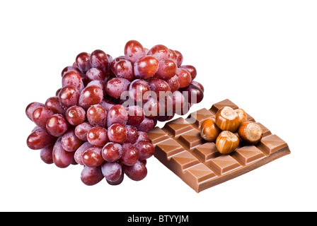 Rote Trauben mit Schokolade und Nüssen in der Schale auf weißem Hintergrund Stockfoto