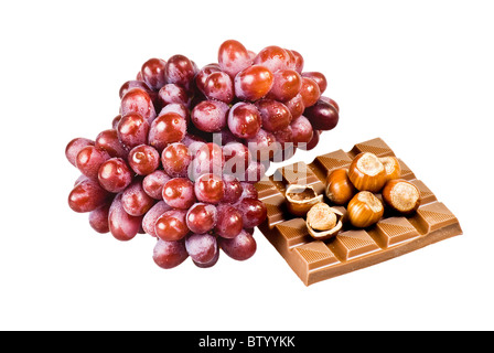 Rote Trauben mit Schokolade und Nüssen in der Schale auf weißem Hintergrund Stockfoto