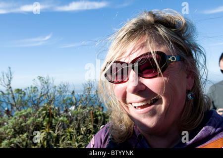 Lachende Frau mit Sonnenbrille zu Fuß entlang der Küste Weg Stockfoto