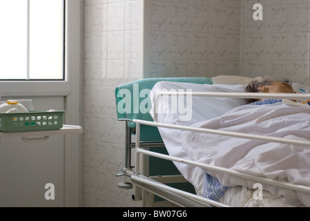 Krankenhaus-Innenraum mit kranken Patienten auf Bett in Polen Stockfoto