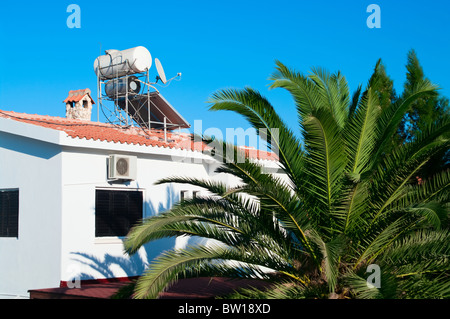 Kessel für die Warmwasserbereitung und Sonnenkollektor auf dem Dach, energiesparende Technologien für Haus in Agia Napa, Zypern, Europa Stockfoto