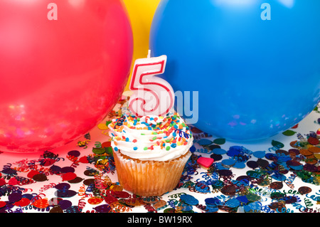 Feier mit Luftballons, Konfetti, Cupcake und Nummer 5 Kerze. Stockfoto