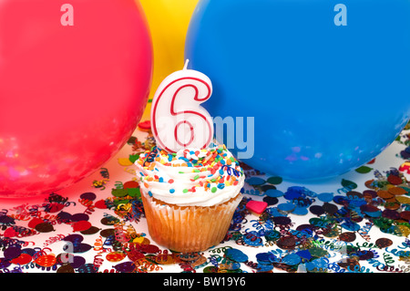 Feier mit Luftballons, Konfetti, Cupcake und Nummer 6 Kerze. Stockfoto