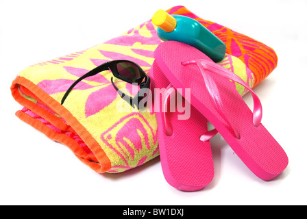 Strandtuch, Flip Flops, Sonnenbrille und Sonnencreme isoliert auf weißem Hintergrund. Stockfoto