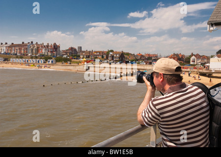 Ein Mann, der die Bilder von der Seebrücke an der Strandpromenade in Southwold, Suffolk, England, Großbritannien, Uk Stockfoto