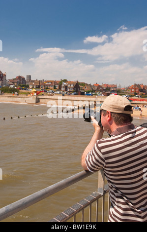 Ein Mann, der die Bilder von der Seebrücke an der Strandpromenade in Southwold, Suffolk, England, Großbritannien, Uk Stockfoto