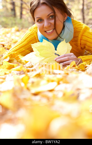 Foto von ruhenden junge Frau liegend auf Laub im Herbst Stockfoto