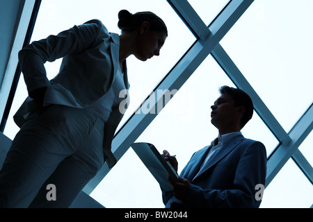 Zwei Silhouetten von Geschäftsleuten, die miteinander im Büro Stockfoto