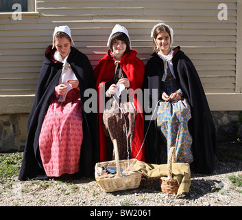 Drei junge Frauen, gekleidet in historischen Kostümen, sitzen im Strawbery Banke Museum in Portsmouth, USA Stockfoto
