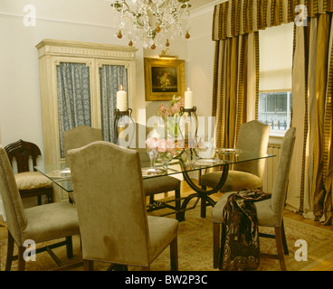 Beige Wildleder gepolsterten Stühlen und Glasplatte Tisch im Speisesaal Stadthaus mit braun + Creme gestreiften Vorhänge Stockfoto