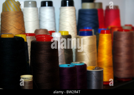 Walzen aus bunter Baumwolle und Thread mit einer Industrienähmaschine einsatzbereit. Stockfoto