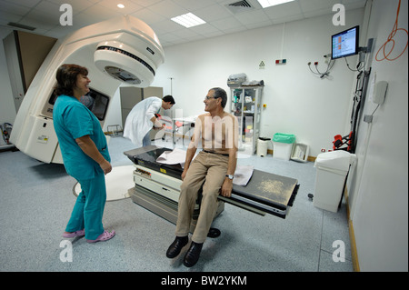 Patienten mit Arzt und Krankenschwester nach einer Strahlentherapie Behandlung mit Hilfe einer linearen Elektron Beschleuniger CLINAC 2100C/D Maschine Stockfoto