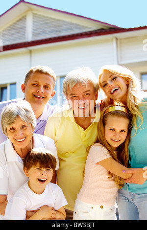 Porträt der glücklichen senior und junge Paare, Blick in die Kamera im Freien mit neuen Hütte im Hintergrund Stockfoto