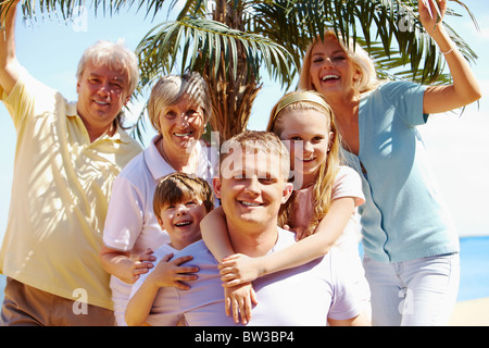 Porträt der glücklichen senior und junge Paare, Blick in die Kamera während der Ferien mit Grünpflanze im Hintergrund Stockfoto