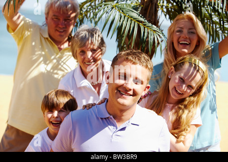 Porträt der glücklichen senior und junge Paare, Blick in die Kamera während der Ferien mit Grünpflanze im Hintergrund Stockfoto