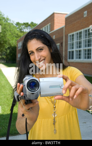 Junge Frau mit Video-Kamera, Camcorder, außerhalb der Schule in Winnipeg, Manitoba, Kanada. Stockfoto