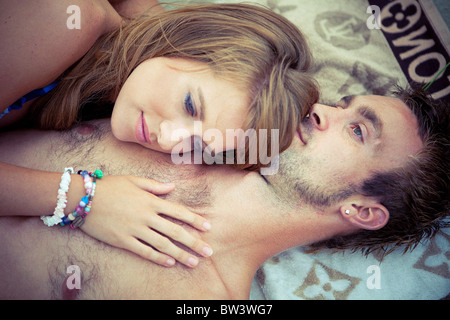 Junges Paar liegen am Strand-Handtuch in Umarmung Stockfoto