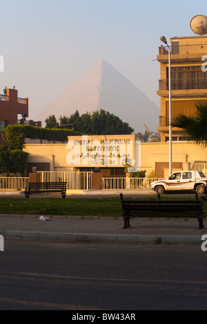 Die imposante Pyramide von Khufu ist schwach sichtbar durch eine Schicht von Dunst und Smog aus einer leeren Straße in Gizeh, Ägypten. Stockfoto