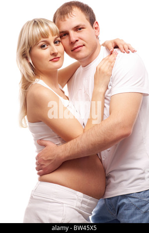 Bild der schwangeren Frau und ihr Mann umarmt und Blick in die Kamera Stockfoto