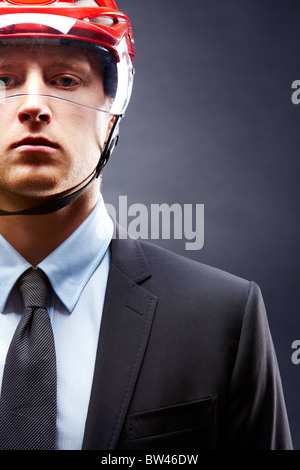 Porträt des jungen Geschäftsmann mit Eishockey Helm auf den Kopf Stockfoto