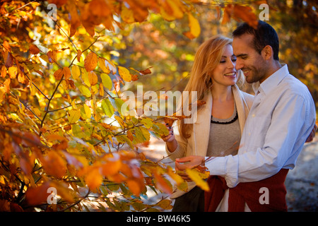 Glückliches Paar amüsieren sich im Herbst im Wald unter braun gelb orange grün Blätter Bäume gehen glücklich Spaß Natur bunt Stockfoto