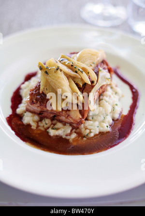 Essen im Delaire Graff Weingut Restaurant. (Schweinebauch mit Fenchel auf einem Bett aus Knollensellerie Risotto) Küchenchef Christiaan Campbell Stockfoto