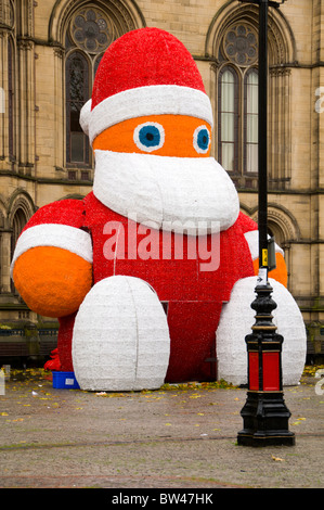 Weihnachtsmann wartet gehoben in Position außerhalb des Rathauses, Albert Square, Manchester, England, UK Stockfoto