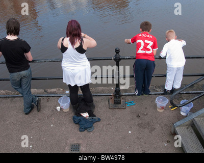 Jungs Angeln an einem Kai mit ihren Eltern. Stockfoto