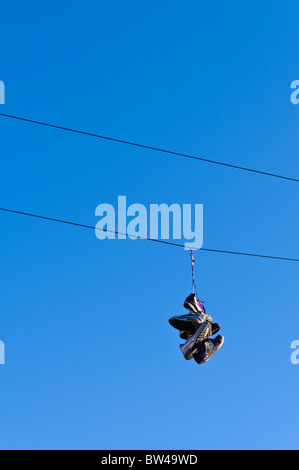 Trainer von einer Telefonleitung hängen Stockfoto