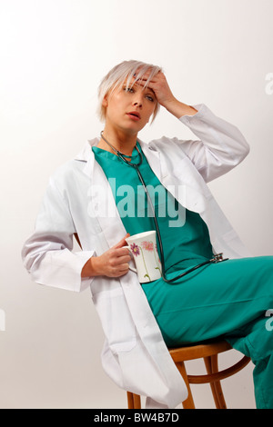 junger Arzt, nachdem eine lange Suche Kaffee trinken erschöpft Stockfoto