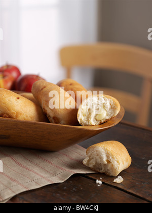 Frisch gebackenen Brötchen in eine Servierschüssel geben. Stockfoto