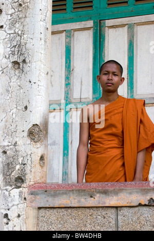 Ein buddhistischer Mönch im Wat Bangkok lebt steht auf der Eingangstreppe aus seiner Wohnräume in Kampong Cham, Kambodscha. Stockfoto