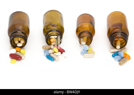 farbige Strom von Pillen, die aus einer Pille Flaschen - auf einem weißen Hintergrund Stockfoto