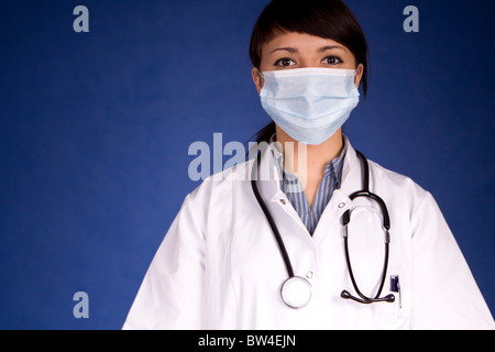 Frau Doktor trägt eine Maske, die Sie untersuchen Stockfoto