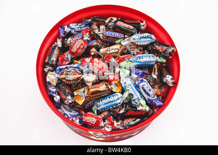 Kunststoff-Container voller Feierlichkeiten Pralinen. Mars, Malteasers, Milky Way, Bounty, Galaxy, Snickers von oben auf weiß. UK Stockfoto