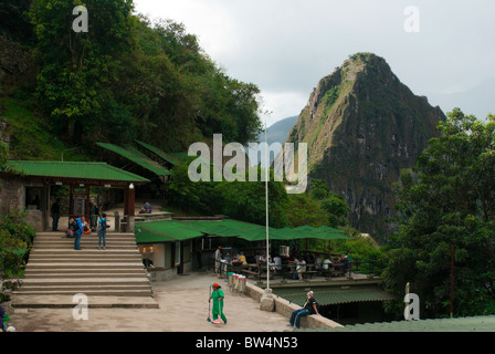 Peru. Machu Picchu, Inka Archäologie Seite, erste Wanderer warten auf Tore öffnen, Frau Bürgersteig fegen Stockfoto