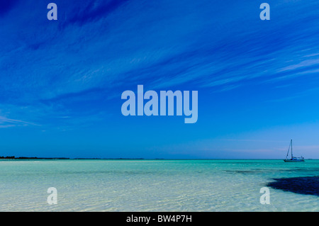 Tropisches Paradies: Türkis sand Strand, yacht Schiff unter blauem Himmel Stockfoto