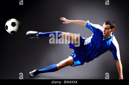 Bild des Fußballspielers fliegenden Kick mit Ball zu tun Stockfoto