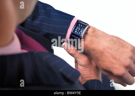 Schließen Sie herauf Bild eines Geschäftsmannes überprüfen der Zeit auf seine Armbanduhr. Stockfoto
