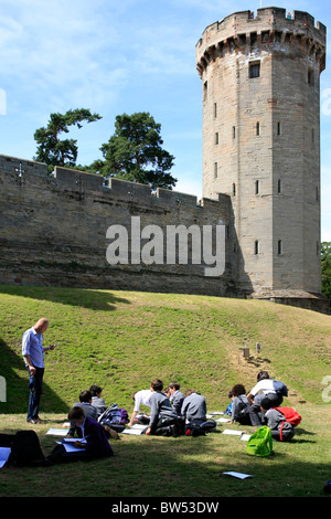 Schülerinnen und Schüler auf einen Tagesausflug nach Warwick Castle nehmen Teil in eine Zeichnung Tutorial vor Kerls Turm Stockfoto