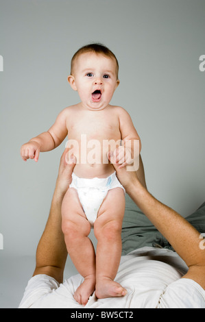 Süße 6 Monate alten Baby stehend auf Papa. Stockfoto