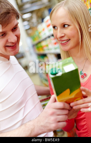 Porträt der weibliche Blick auf lächelnd Mann im Supermarkt bei der Auswahl von Saft Stockfoto