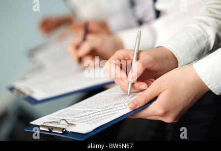 Zeile der Hände von Geschäftsleuten, die Abhaltung von Dokumenten und Stifte Stockfoto