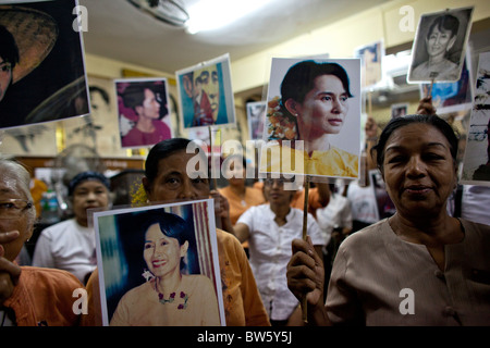 Unterstützer von Aung San Suu Kyi halten ihre Porträts, wie sie in der Nationalliga für Demokratie (NLD) Hauptsitz sammeln Stockfoto