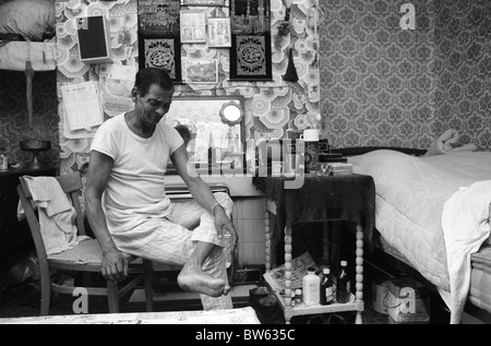 Asiatische Muslimischen 1980 s UK zugewanderten Menschen als Mann im Bett Wohnzimmer, dass er mit seiner Frau teilt Blackburn, Lancashire, England. Er ist krank. 1983 HOMER SYKES Stockfoto