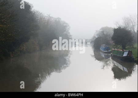 Narrowboats auf der Themse nur stromaufwärts von Godstow Schloss an einem nebligen Tag. Stockfoto